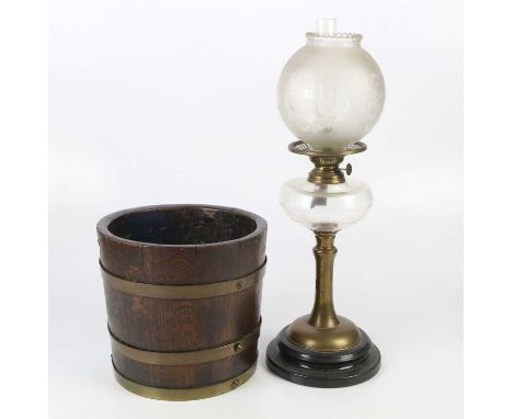 A 20th century brass oil lamp with replacement frosted glass shade and clear glass reservoir, height 53cm, and coopered bucke