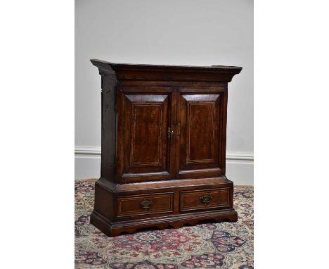An 18th century wall hanging cupboard, with moulded cornice above the two inlaid doors housing a single fixed shelf above two