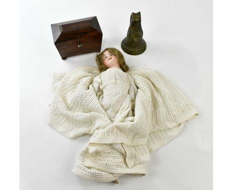 A small 19th century rosewood tea caddy, width 19cm, an Armand Marseille bisque head doll and a large decorative brass bell, 