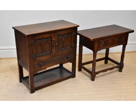 A reproduction oak two door cupboard, with two carved and panelled doors above single drawer and under tier, width 81cm, dept