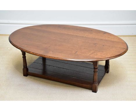 A reproduction oak oval topped coffee table with undertier, on block legs, length 120cm, height 43cm.