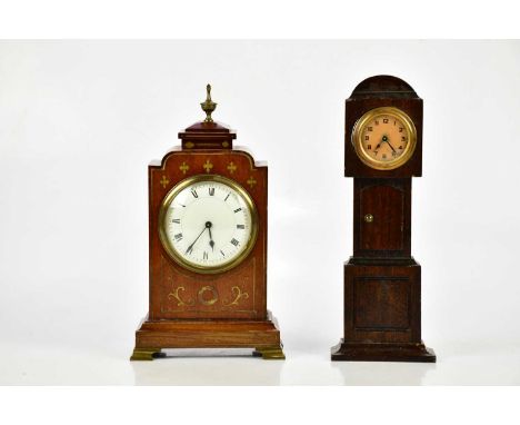 A late 19th century brass inlaid mahogany mantel clock, with brass urn finial above the enamel dial set with Roman numerals a