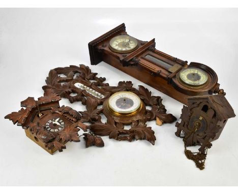 A Black Forest carved wood combination barometer and therometer, length 55cm, with two cuckoo clocks and an Edwardian combina