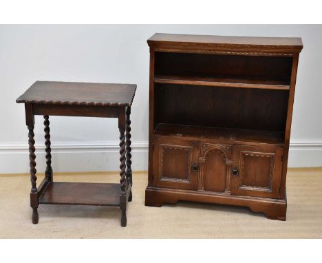 A reproduction oak freestanding bookcase with a fixed shelf above two panelled cupboard doors, width 84cm, depth 25cm, height
