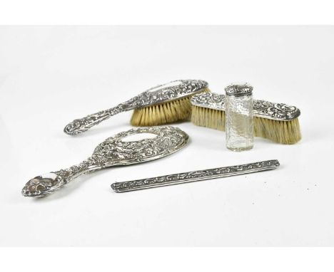 A matched hallmarked silver four piece dressing table set and glass dressing table bottle with hallmarked silver top, the han
