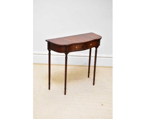 A reproduction mahogany serpentine front side table on turned column legs, height 72cm, width 80cm, depth 34cm.