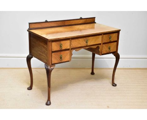A 1950s walnut kneehole dressing table with an arrangement of five drawers on carved cabriole supports, width 107cm, depth 52