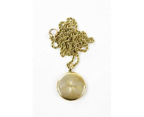 A 15ct yellow gold locket with engine turned decoration suspended on a yellow metal rope link chain, indistinctly stamped, to