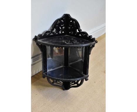 A Victorian ebonised corner shelf with mirrored back and pierced decoration, height 58cm.