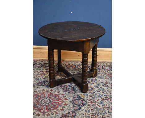 A James I oak credence table with an oval flat top and triangular frieze on bobbin turned legs with gateleg action, width 81c