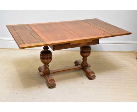 An Edwardian golden oak extending dining table, on baluster legs, size closed height 75cm, width 91cm.
