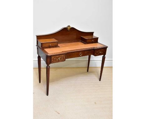 A reproduction French style writing table with raised back and tooled leather top with an arrangement of five drawers on flut