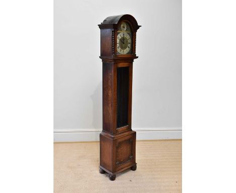 An early 20th century oak longcase clock, with St Michael Westminster and Withington chimes, on bun feet, complete with three