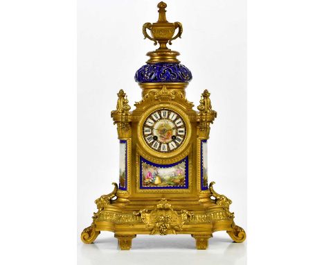 A 19th century French ormolu and porcelain mantel clock with twin handled urn finial above the reticulated ceramic column, wi