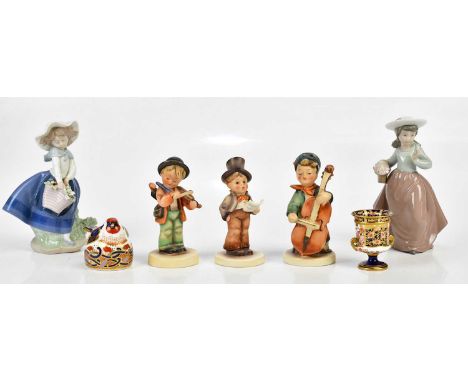 LLADRÓ; a figure of a girl holding a basket of flowers, a Nao figure of a girl walking, three Goebel Hummel figures, a Royal 