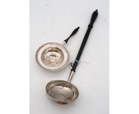 A silver tea strainer, by William Hutton &amp; Sons, London, with a Greek key pattern rim and turned wooden handle, and a pla