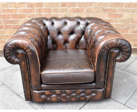 A BROWN LEATHER BUTTON UPHOLSTERED CLUB ARMCHAIR with additional set of cushions, originally retailed by Thomas Lloyd, 107cm 