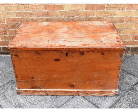 A STAINED PITCH PINE TRUNK  with iron carrying handle to each end, 96cm wide 57cm deep 52cm high