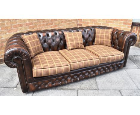 A BROWN LEATHER BUTTON UPHOLSTERED THREE SEATER CHESTERFIELD SOFA  with additional set of cushions, originally retailed by Th