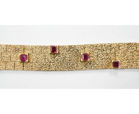 A textured yellow metal and eleven stone square cut  ruby set bracelet, 16.5cm, gross weight 36.8 grams.