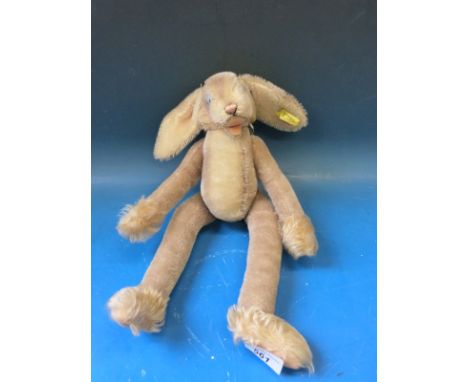 A Steiff mohair rabbit with jointed limbs, glass eyes and original button and label to ear (47cm tall)