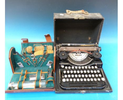 A leather cased travelling set with brushes, scissors, needles etc and a vintage cased portable typewriter