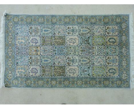 A Persian silk carpet with decorated panels (160 x 90cm)