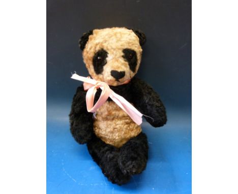 A vintage panda bear with jointed limbs probably Merrythought or Chiltern Hygienic Toys, 36cm tall. 