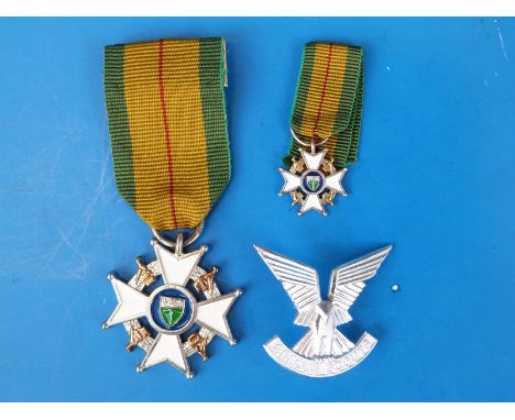 A Rhodesian Member of the Legion of Merit Medal and Selous Scouts cap badge. Purchased by the vendor from the family of 64418