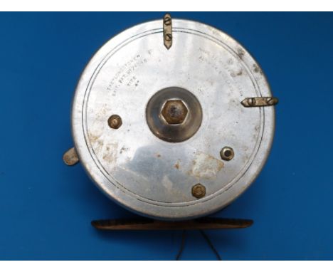 A Hardy Bros The Longstone 4" fishing reel with twin brown handles and brass ribbed foot, patent number 24245. 