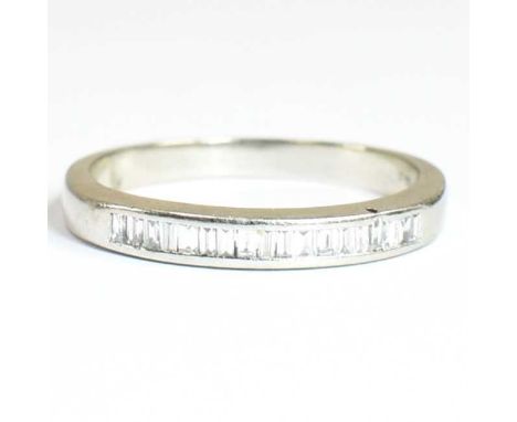 A hallmarked 9ct gold and diamond half eternity ring. The ring having channel set baguette diamonds to plain band. Ring size: