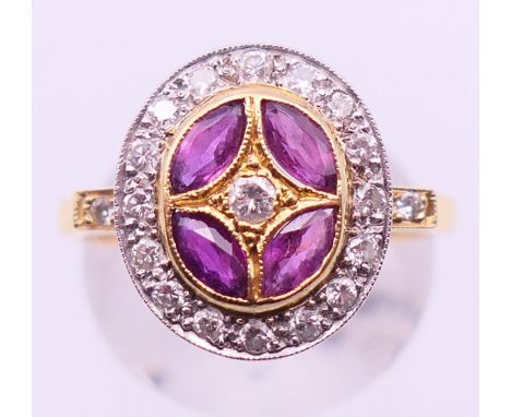 An 18 ct gold, diamond and ruby target ring. Ring size P.