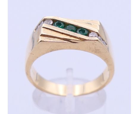 A 14 K gold diamond and emerald gentleman's ring. Ring size T/U. 
