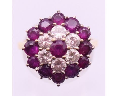 An 18 ct gold, diamond and ruby cluster ring. Ring size P.