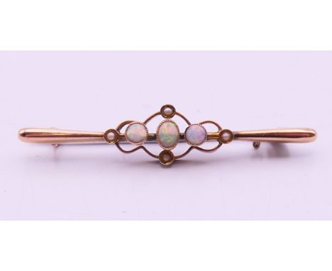 A Victorian unmarked 9ct gold opal and seed pearl bar brooch.  5 cm long. 1.8 grammes total weight. 