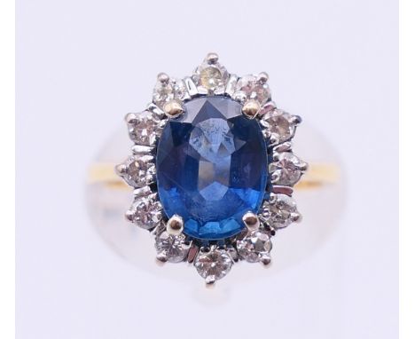 An 18 ct gold, diamond and blue stone ring. Ring size J. 