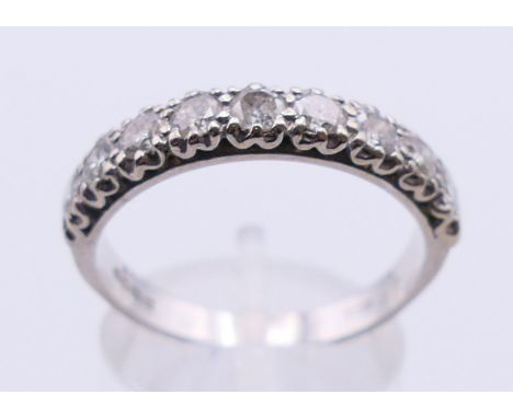 An 18 ct white gold and diamond nine stone diamond ring. Ring size T.