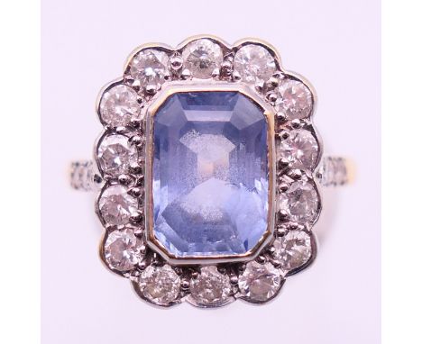 An unmarked gold, diamond and blue stone ring. Ring size P. 
