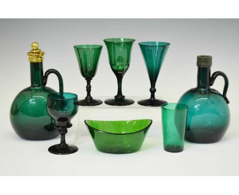 Collection of mainly 19th century emerald green glass tableware, comprising two decanters, four wine glasses, tumbler, and el