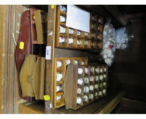A large collection of commemorative ceramic thimbles, with display racks