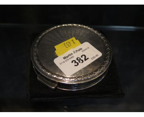 A silver circular compact with engine turned detail, Birmingham 1957, together with a square shaped compact with floral etche
