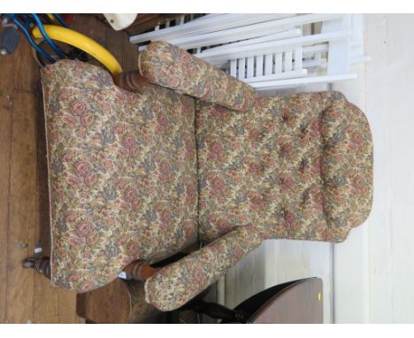 An Edwardian button upholstered walnut armchair, with turned supports and pot castors
