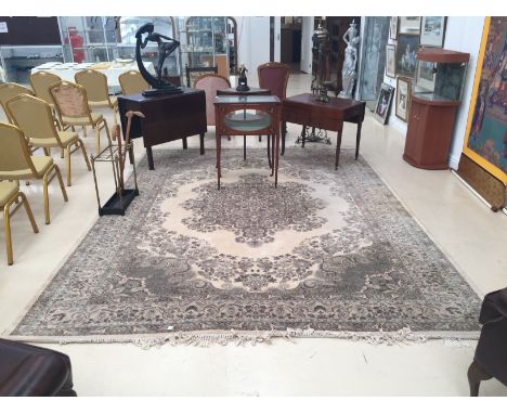 A large hand-made Keshan carpet in muted colours with foliate designs