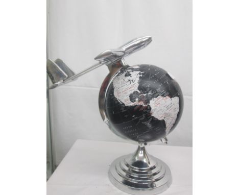 A chrome globe with twin engine jet