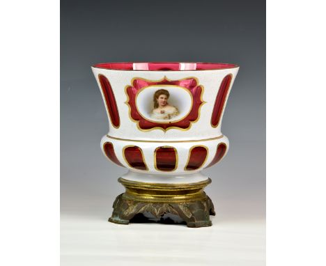 A Bohemian cased glass portrait bowl, early 20th century, the flared, squat baluster bowl in white cased ruby glass, with gil