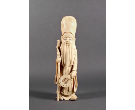 A Chinese carved ivory figure of the immortal Shou Lou, Qing Dynasty, with high domed hat, holding in one hand a gnarled staf