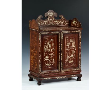 A Chinese hardwood and ivory inlay table cabinet, c.1900, panelled top with shaped apron above a pair of rectangular doors en