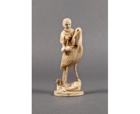 A Japanese carved ivory okimono, Meiji period (1868-1912), of a man riding on the back of a crane and holding the string of a