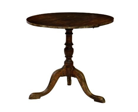 A George III mahogany tripod table, the circular top over a baluster turned column raised to three swept supports on pad feet