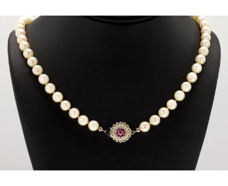 A pearl necklace with a 14ct white gold and ruby clasp, the pearls measuring approximately 8mm in diameter and closed with a 